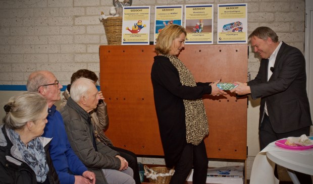 Wethouder Rob Opdam overhandigt een tablet aan Angelique Besseling.