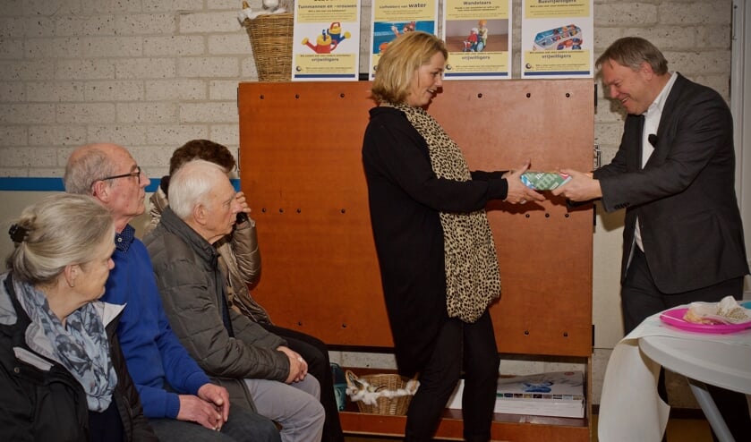 Wethouder Rob Opdam overhandigt een tablet aan Angelique Besseling.