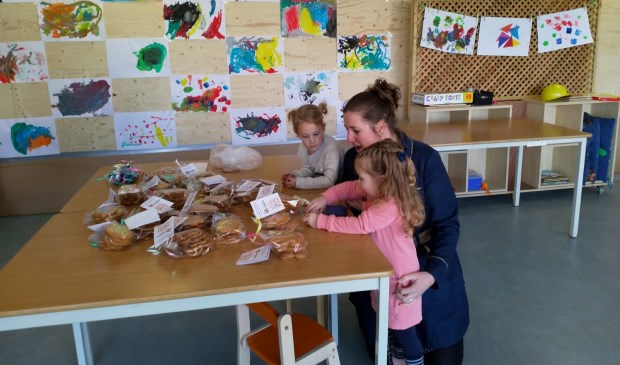 Phileine en Noortje zijn druk bezig met de verkoop van de koekjes