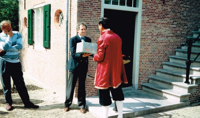 Er werd een cadeau overhandigd namens Het Bouwfonds; wethouder Dinand de Ridder bekijkt het tafereel.
