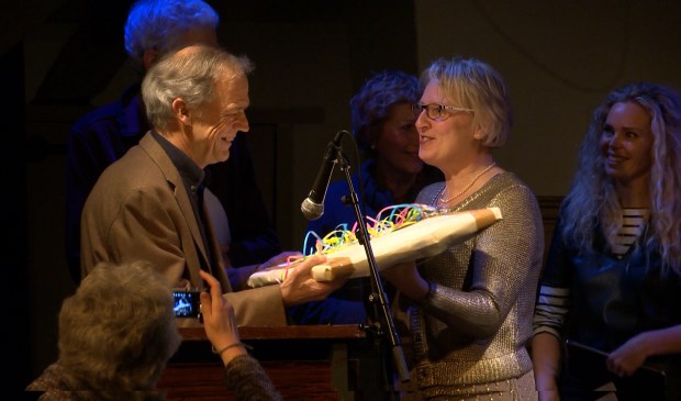 Winnaar Willibrord Ruigrok krijgt uit handen van wethouder Marianne Verhage een kunstwerk.
