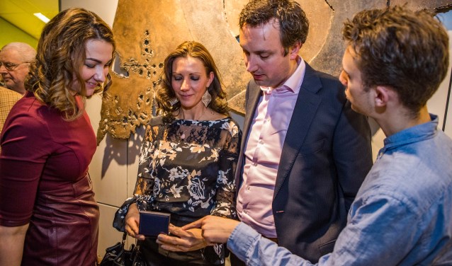 De familie van De Wild bekijkt de in ontvangst genomen gemeentespeld nog eens goed. Foto : Bastiaan Miché