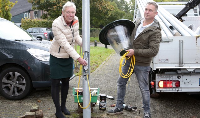 Wethouder Boersen sluit de eerste lichtmast in de Bijvanck aan op LED-verlichting. Zij wordt hierbij ter zijde gestaan door Olaf de Schouwer van de BEL Combinatie.