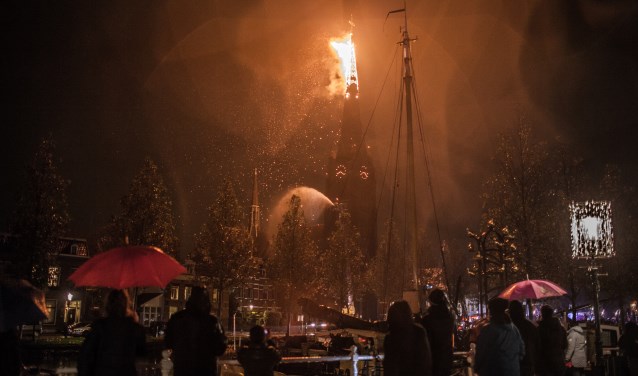 De brandende torenspits voor hij afbreekt en naar beneden stort.