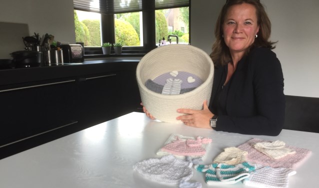 Karin Timmerman met het haakwerk en mandje dat zij maakt voor ouders die een beroep doen op stichting Still.