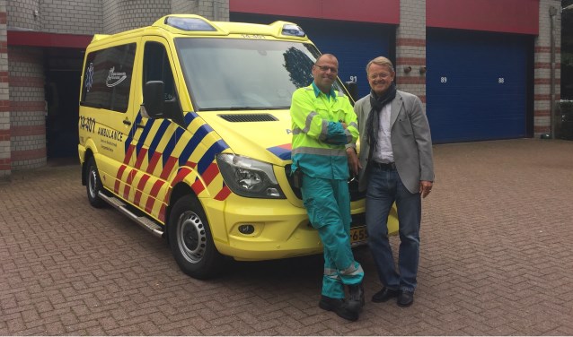René Ton (r.), directeur van RAV Gooi en Vechtstreek, en Hans Wesdijk, ambulancechauffeur en wagenparkbeheerder, voor de nieuwe zorgambulance