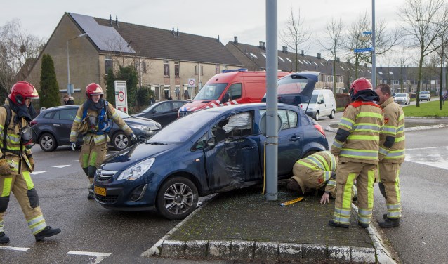De brandweerlieden bekijken de auto met de gescheurde benzinetank.