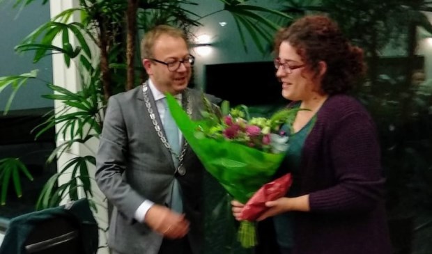 Bloemen van burgemeester Van Benthem voor vertrekkend raadslid Beppie Hoek.