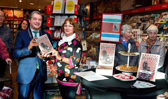 Ingrid Mijnes overhandigt een exemplaar van het boek aan burgemeester Boog.