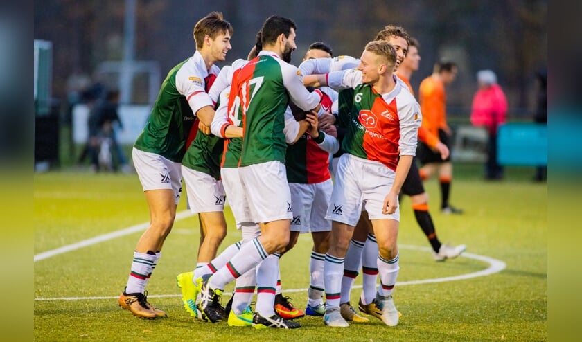 De spelers van Olympia juichen na weer een treffer.