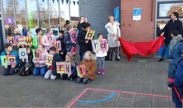 Onder toeziend oog van de leerlingen onthullen de wethouders het bordje rookvrij.