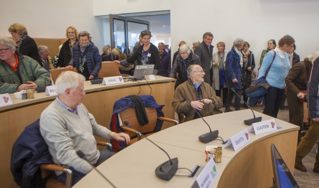 De stoelen in de gemeenteraad uittesten.