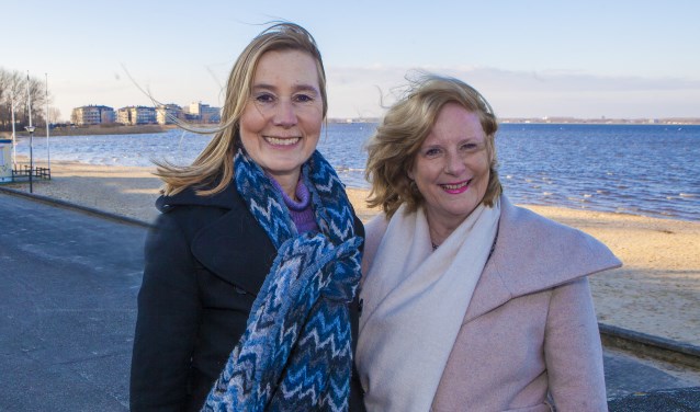 Lijsttrekkers Jessica Prins van de VVD (links) en Marlous Verbeek van D66 trotseren de straffe wind voor een foto bij het strand.
