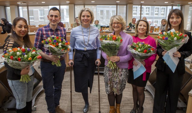 De nieuwe Nederlanders op de foto met de wethouder.