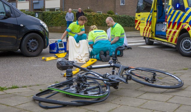 Ambulancepersoneel behandelt de aangereden wielrenner.