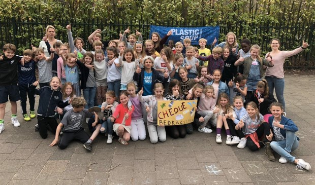 De groepen 6 met Petra Olgers (in het midden met blauw shirt) en de cheque.