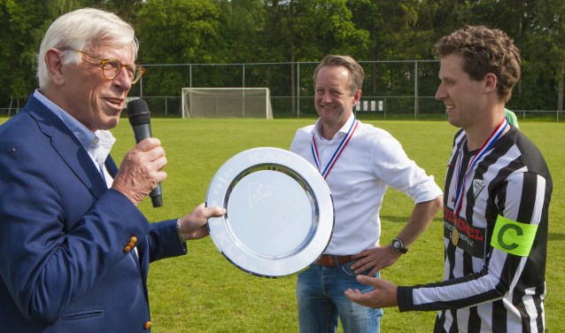 Wethouder Ton Stam overhandigt de kampioenschaal.