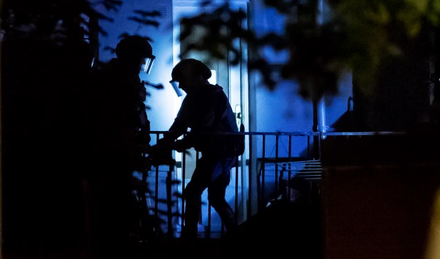 De politie in actie tijdens de inval bij de woning aan de Larenseweg.