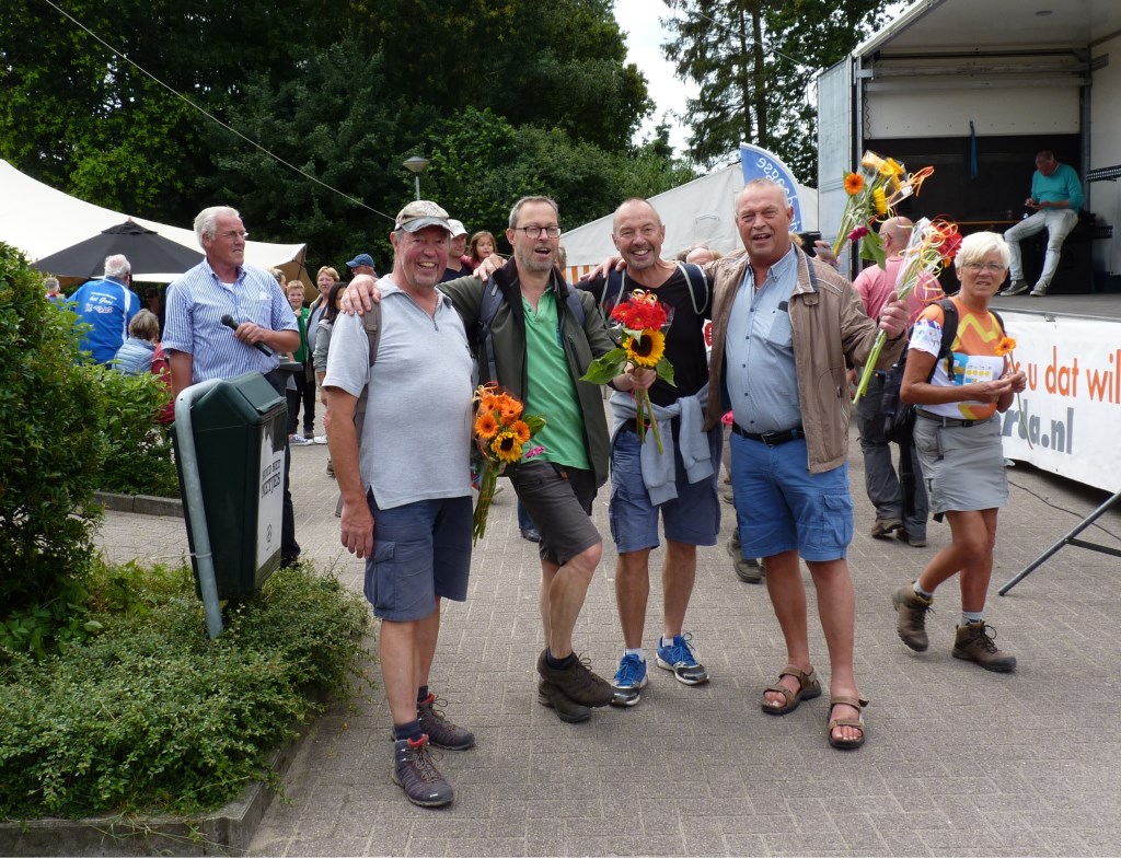 Cock (r) verwelkomt zijn broers Jan, Arnold en Gerard Smit met fleurige boeketten.