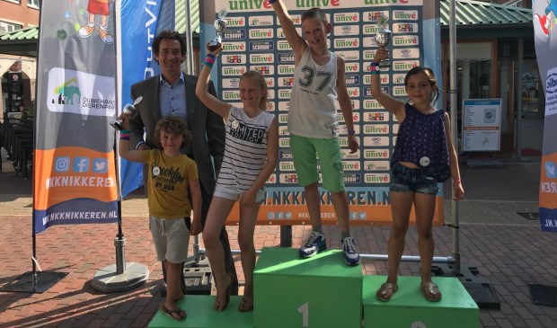 Wethouder Roland Boom met de vier besten van het Huizer Knikkerkampioenschap.