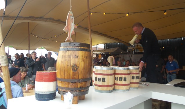 Burgemeester Sicko Heldoorn veilde de haring van de eerste Huizer Haringrace.