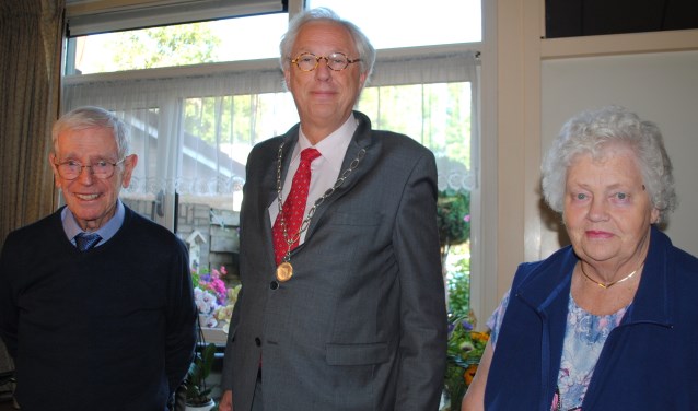 Burgemeester Van Bochove (m) op bezoek bij meneer en mevrouw Herremans-Baars.