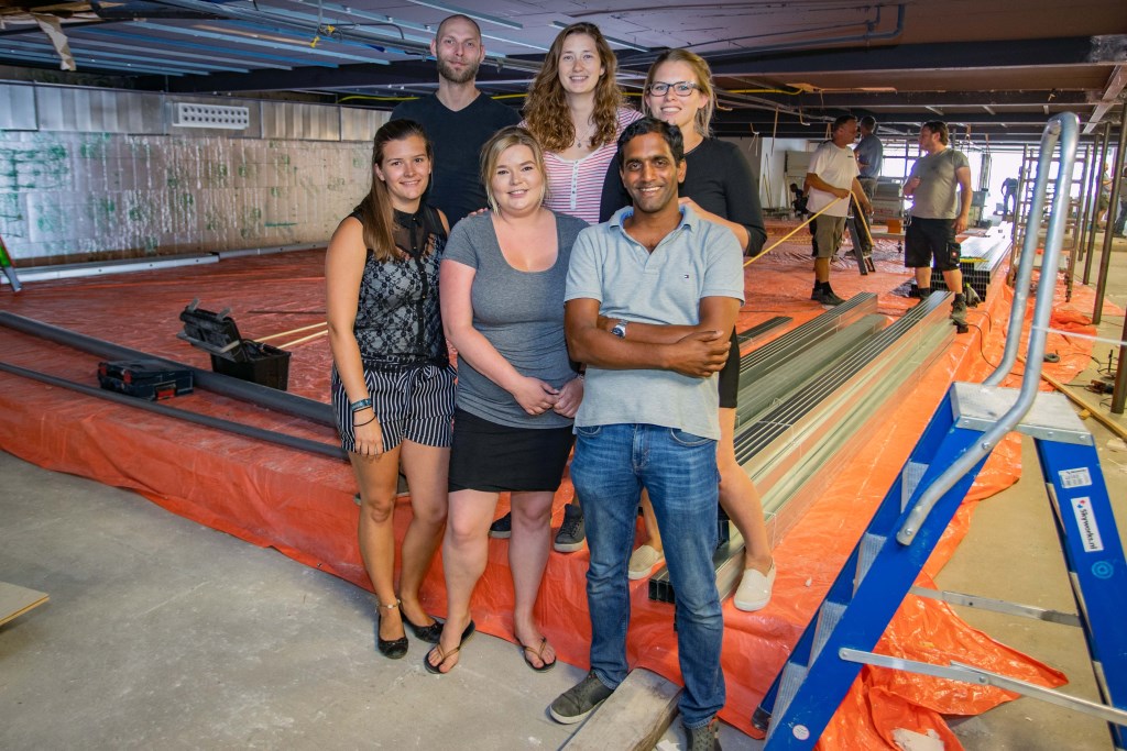 Shiva de Winter met een aantal werknemers voor het zwembad van 17,5 bij 7,5 meter.