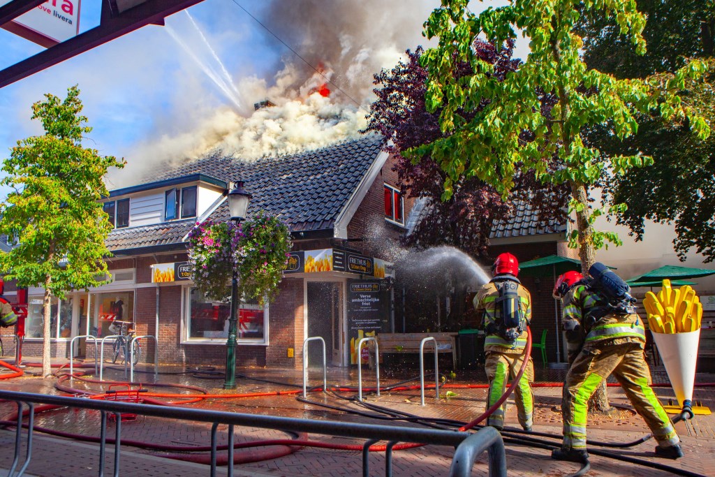 De brandweer is met man en macht in de weer om de brand te blussen.