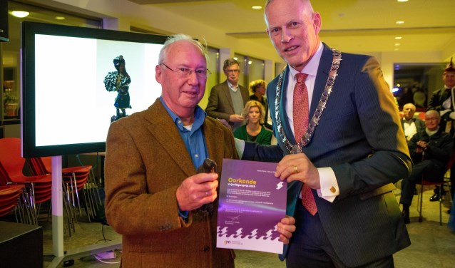 Ed Boshuijzen krijg uit handen van Han ter Heegde het Naardens Compliment.