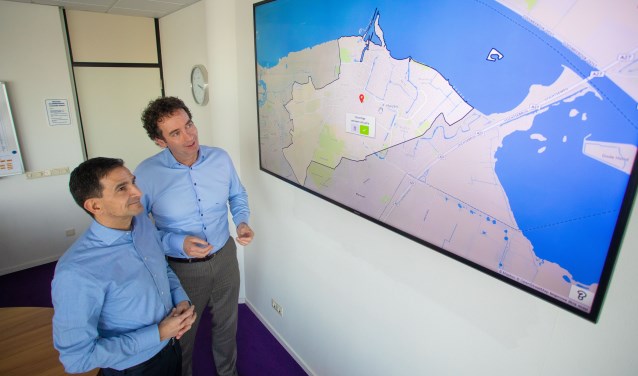 Wethouders Maarten Hoelscher (l) en Roland Boom laten zien hoe een onveilige situatie op de kaart kan worden aangegeven bij het onderzoek.