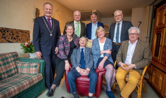 Harrie Schepens is het feestelijk middelpunt tussen zijn kinderen en met de burgemeester op de foto.