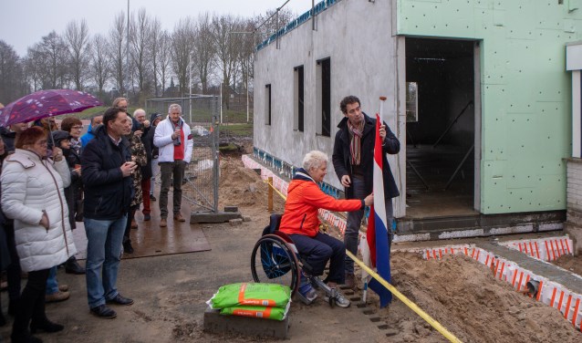 Wethouder Roland Boom en atleet Djoke van Marum staan klaar om de vlag te hijsen om het hoogste punt van de nieuwbouw te vieren.