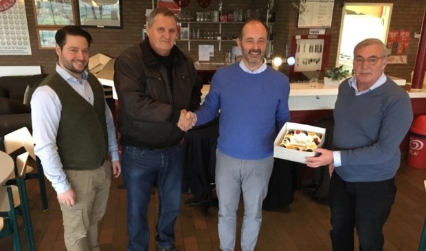 Marco Wiesehahn, (tweede van rechts) overhandigt de taart aan Frits Hogguer (rechts) en Adri van ’t Hoenderdal (tweede van links), in aanwezigheid van Sjoerd van Klink (links).