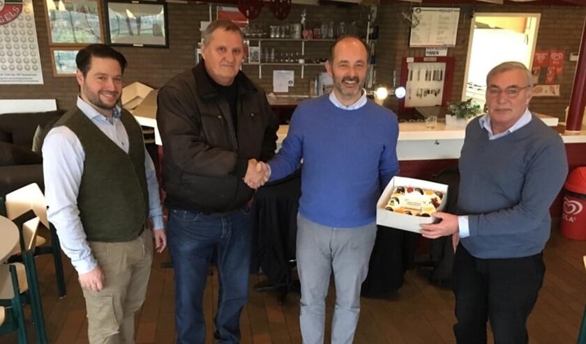 Marco Wiesehahn, (tweede van rechts) overhandigt de taart aan Frits Hogguer (rechts) en Adri van ’t Hoenderdal (tweede van links), in aanwezigheid van Sjoerd van Klink (links).