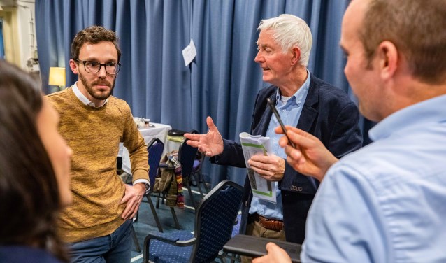 Wethouder Scheepers (links) in gesprek met enkele aanwezigen tijdens het eerste buurtgesprek in De Geus.