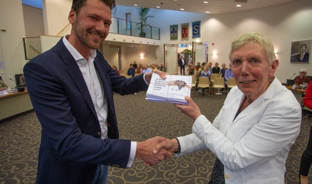 Buijks overhandigt de handtekeningen aan de wethouder.
