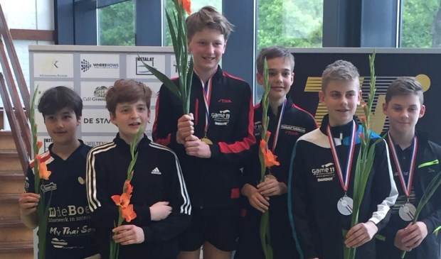 Teun (midden links) met zijn partner Mate zijn Nederlands Kampioen tafeltennissen.