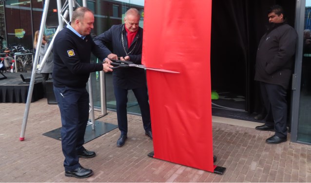 Burgemeester Sicko Heldoorn en supermarktmanager Jack knippen het lint door.