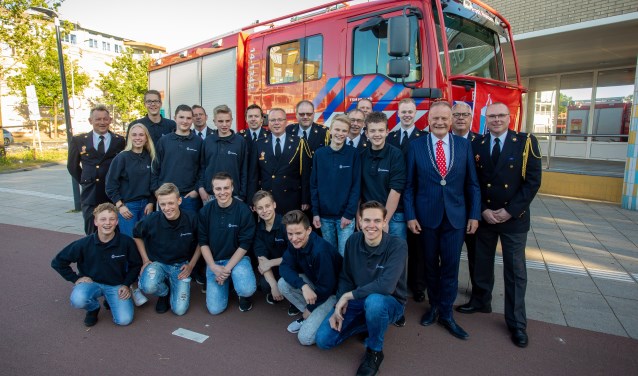 De jeugdbrandweer met begeleiding met links brandweercommandant John van der Zwan en rechts postcoördinator Fred Kos, geflankeerd door de burgemeester.