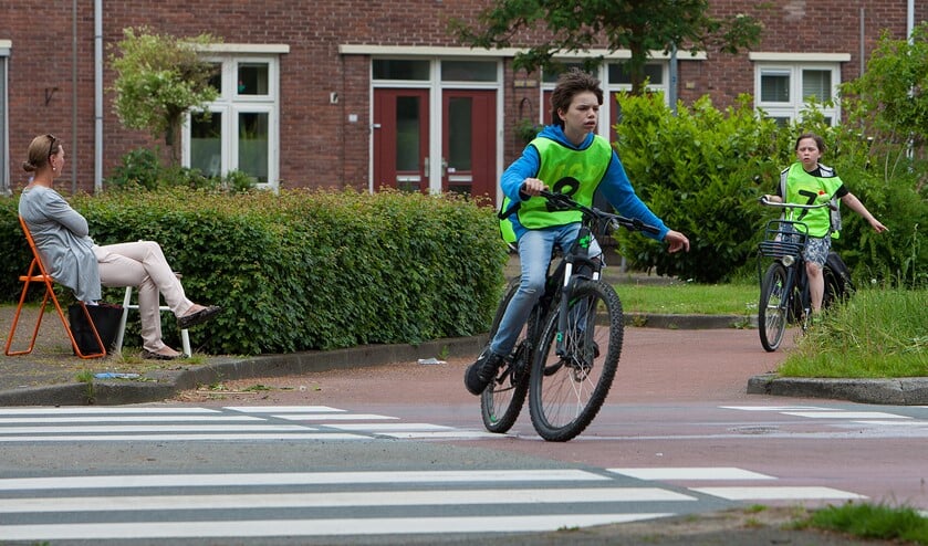 Deze leerlingen steken netjes hun hand uit bij een controlepost.