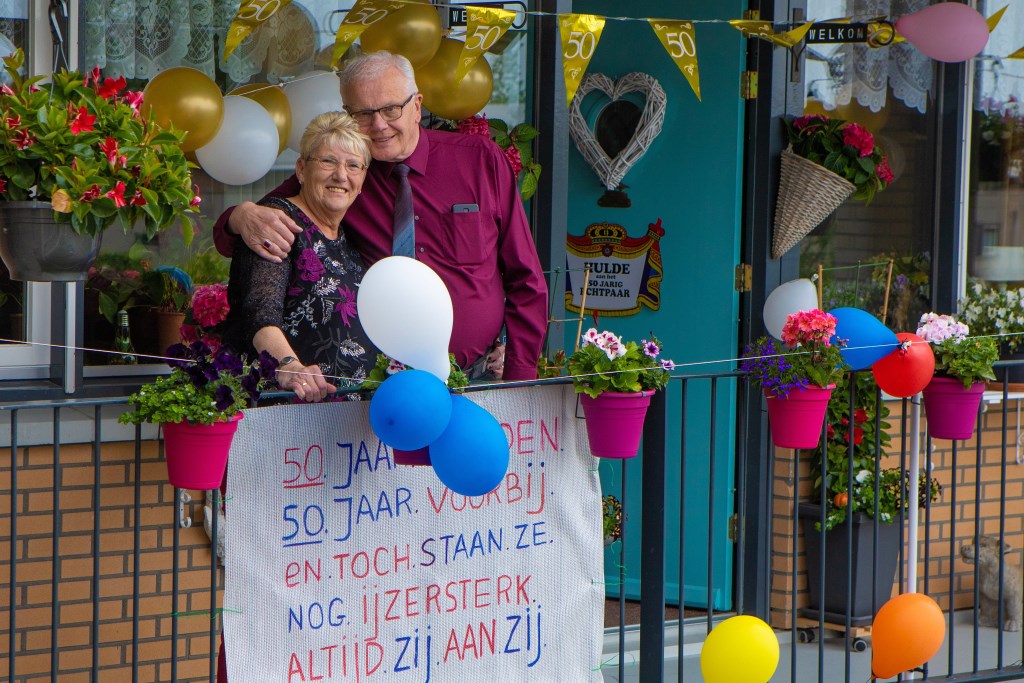 Thea en Bert Smeink bij hun feestelijk versierde huis.