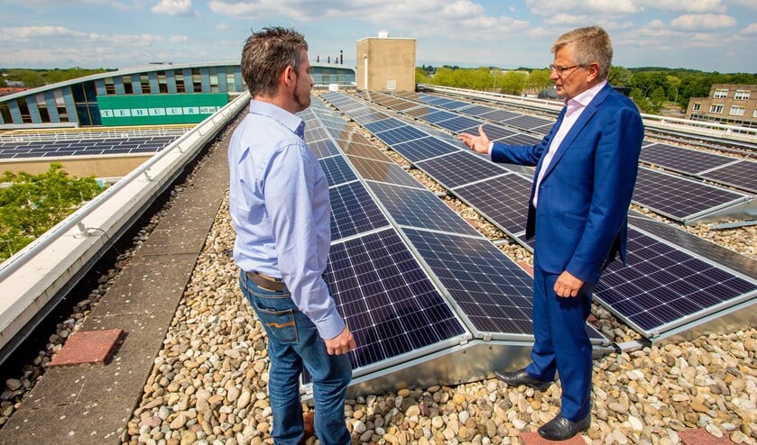Wethouder Bert Rebel (rechts) met de gemeentelijke gebouwbeheerder op het dak.