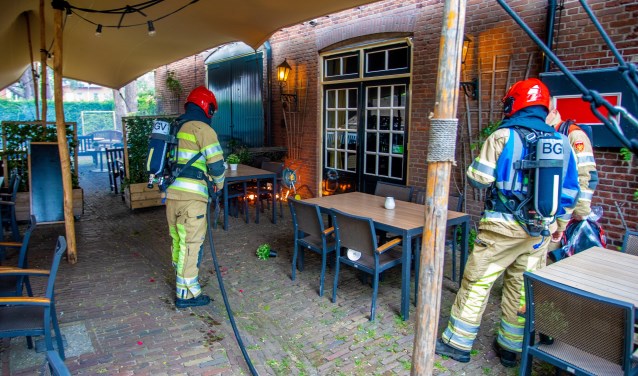 De brandweer blust de plantenbak.