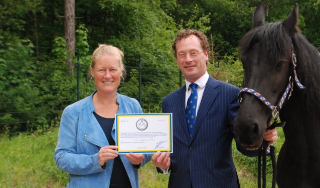 Lisette Bakker ontvangt de cheque van Jasper. Het paard Yfke is al langer bij de manege.