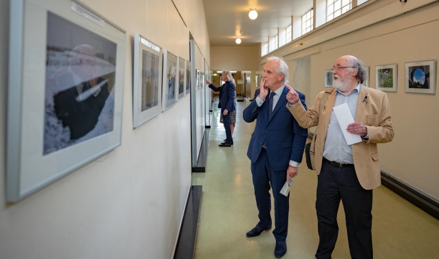 Burgemeester Pieter Broertjes bekijkt samen met Philip P. Kruijer de foto's.