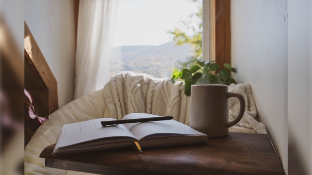 A cozy mental health break with an open journal, pen and coffee cup.