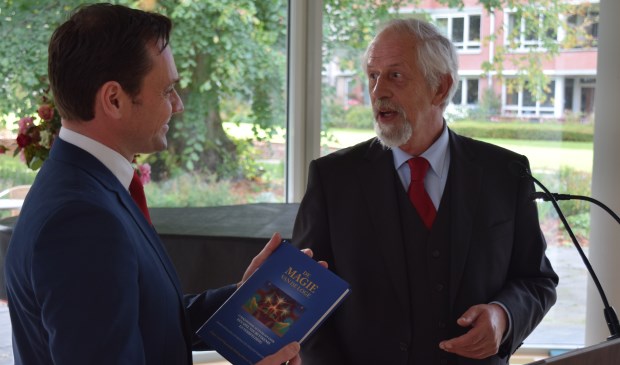 Grootmeester Gerrit van Eijk overhandigt het boek ‘Magie van de loge’ aan burgemeester Sjoerd Potters.