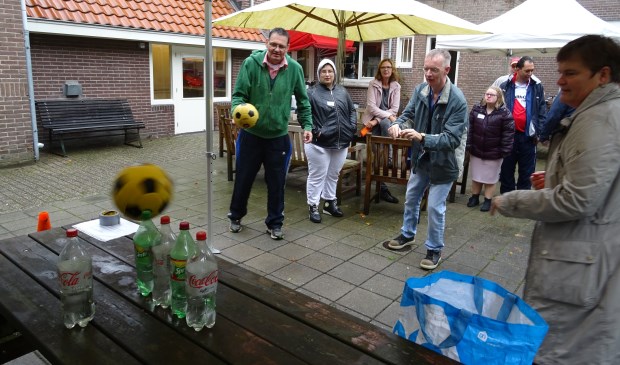 Onder aanmoediging van spelbegeleider en wethouder Anne Brommersma probeerden de deelnemers in drie worpen zoveel mogelijk flessen van de tafel te gooien.