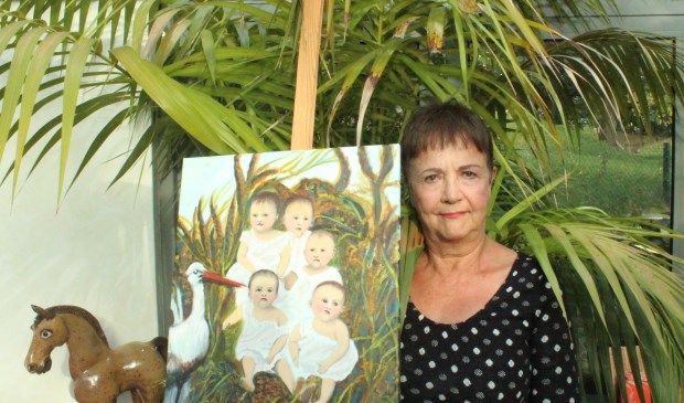Ada Holvast naast een schilderij dat zij maakte van de omslag van het boek 'Uit het leven van baker Hannemeu en Kneel, bakeren in de Bommelerwaard'.