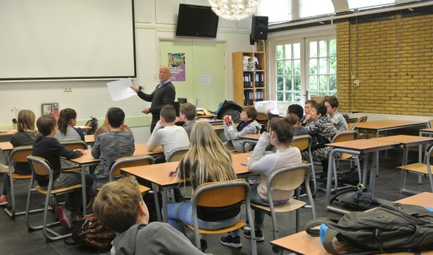 Frans Poot bespreekt met de leerlingen de door hen geschreven teksten.